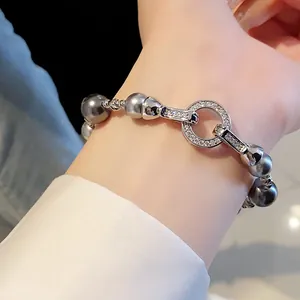 Primo piano dettagliato di un braccialetto in zircone argento e perle grigie stile francese al polso