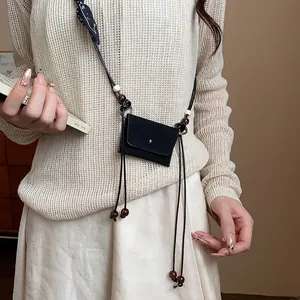 Dettaglio della mini borsa in tessuto retrò con catena in vita e perline