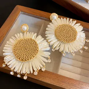 Detailansicht der böhmischen Gänseblümchen-Ohrringe mit Strohgeflecht und Perlen.