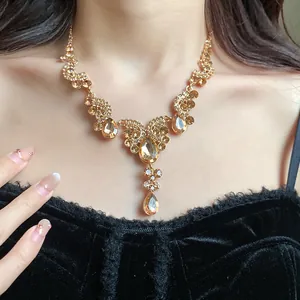 Close-up of champagne gold fan teardrop necklace featuring vintage rhinestone details.