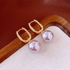 Detail shot of French vintage gold hoop earrings featuring zircon accents and purple pearls