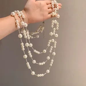 Close-up detail of elegant multi-layered French vintage pearl necklace held by hand
