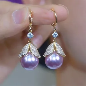 Close-up of lavender faux pearl dangle earrings with sparkling zircon accents and gold finish