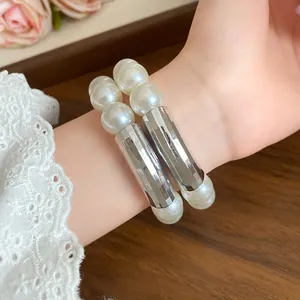 Elegant close-up of a vintage double-layered pearl bracelet with silver cylindrical beads