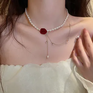 Close-up of elegant double-layered pearl necklace with a red camellia pendant