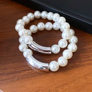 Detailed macro view of elegant French retro pearl necklace with silver tube accent.