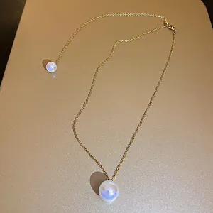 Detailed view of an elegant gold chain necklace featuring lustrous iridescent pearl pendants.