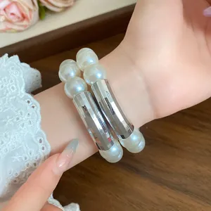 Elegant double-strand pearl bracelet with polished silver metal tubes shown on a wrist detail