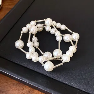 Detailed view of white pearls and silver tube spacers on a French vintage style necklace
