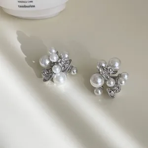 Close-up of vintage pearl cluster earrings with silver orb motif in a soft cream setting