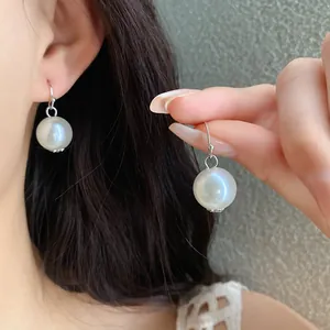 Detailed view of elegant French vintage pearl drop earrings with iridescent sheen.