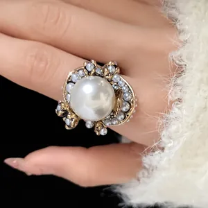 Macro close-up of a vintage French style pearl ring with ornate gold flower detailing