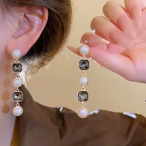 Detail view of elegant faux pearl and zircon dangle earrings in French retro style