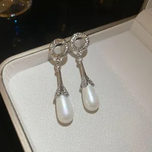 Close-up of vintage French style teardrop pearl earrings with zircon detail.