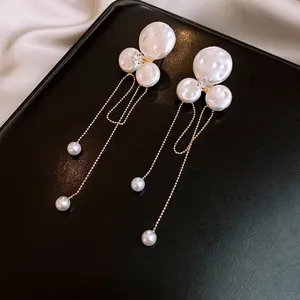 Detailed view of elegant baroque pearl earrings with zircon and long gold tassels