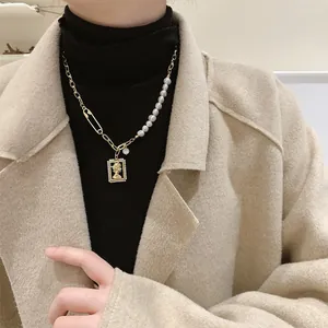 Vintage Baroque pearl necklace with gold portrait pendant on model in beige coat