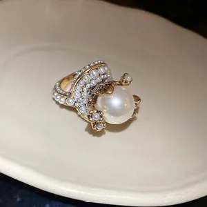 Detailed close-up view of a French vintage pearl flower ring with elegant golden leaf accents