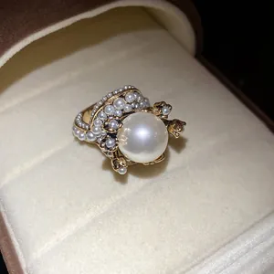 Close-up of vintage French style pearl ring with golden flower metal textures and details