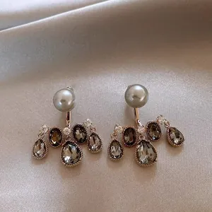 Detailed view of vintage-style drop earrings with grey pearls and smoky gemstones.