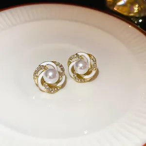 Close-up detail of French vintage gold-toned earrings with round pearl and zircons