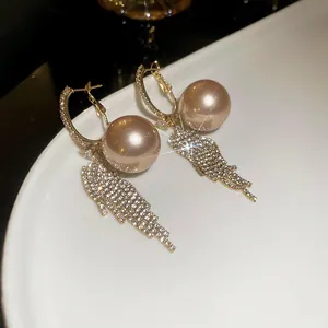 Elegant macro view of champagne pearl drop earrings featuring sparkling zircon tassels