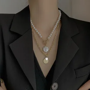 Close-up of double-layered necklace with baroque pearls and gold-tone chain detail