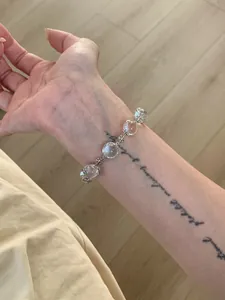 Vue détaillée d'un élégant bracelet flocon de neige en perles de verre sur un poignet.