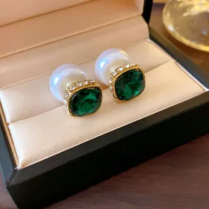 Detailed view of vintage French earrings with green zircon and pearl in a jewelry box