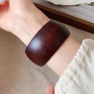 Détail en gros plan d'un bracelet jonc rétro en résine avec texture bois sombre