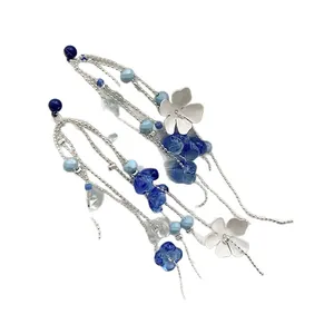 Handmade silver tassel earrings featuring blue glass beads and delicate white floral charms