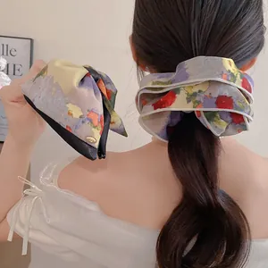Vue détaillée de dos d'un modèle portant un chouchou floral et une pince à nœud