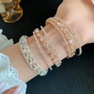 Primer plano elegante de brazaletes abiertos de circonio multicapa con acabado de oro rosa en muñeca