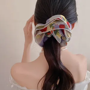 Chouchou floral double couche présenté sur une élégante queue de cheval basse