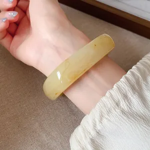 Détail macro d'un bracelet en résine vintage irrégulier avec texture marbre au poignet