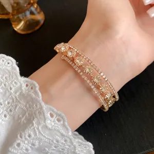 Detalle exquisito de un brazalete abierto de circonitas de tres capas en oro rosa
