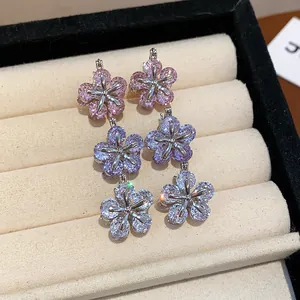 Detail of sparkling three-tier flower drop earrings with cubic zirconia stones.