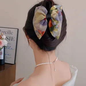 Vue arrière détaillée d'une pince à cheveux rétro française en tissu fleuri style peinture