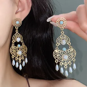 Dettaglio delle orecchini a fiore in smalto stile vintage di palazzo con perle