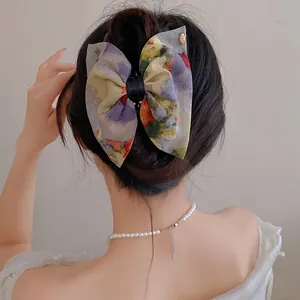 Vue rapprochée d'un nœud papillon en tissu floral vintage français sur cheveux sombres