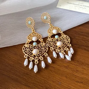 Vista dettagliata di orecchini vintage stile palazzo dorato con perle ed eleganti perline