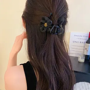 Élégante pince à cheveux fleur en résille noire pour femme vue de dos sur cheveux longs