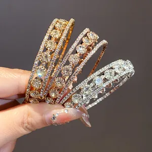 Elegante conjunto de brazaletes abiertos de tres capas de circón para mujer en la mano