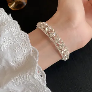 Primer plano de un elegante brazalete de tres filas de circonitas y encaje
