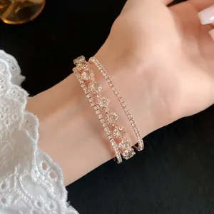 Detalle de un brazalete de tres capas en oro rosa con circonitas cúbicas en la muñeca