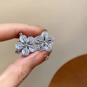 Detailed close-up of sparkling flower earrings with brilliant zircon stones for women.