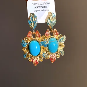 Dettaglio degli orecchini vintage in smalto con pietre turchesi ovali stile barocco