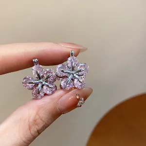 Detailed close-up of sparkling pink zircon flower-shaped earrings in silver setting