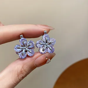 Close-up of sparkling purple zircon flower earrings with intricate silver setting