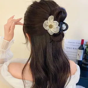 Vue détaillée d'une pince à cheveux fleurie en tulle élégante sur un chignon bas