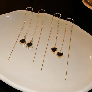 Elegante goldene lange Quastenohrringe mit schwarzen Herz- und Quadratanhängern